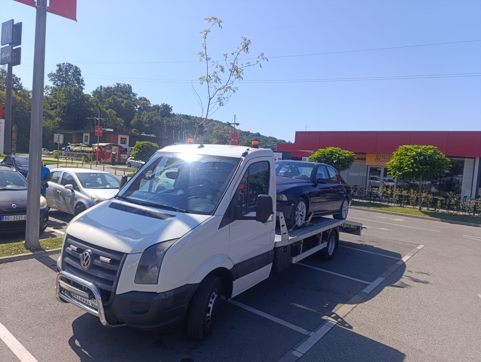 Heavy-duty tow truck transporting a commercial truck on highway