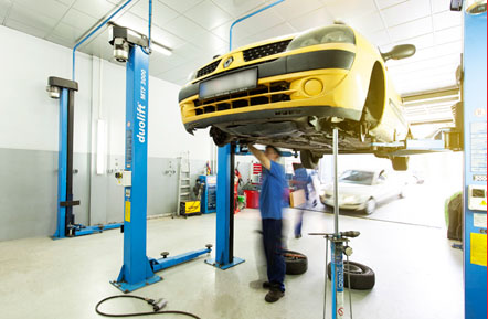 Tow truck hauling a sedan on a city street with professional operator
